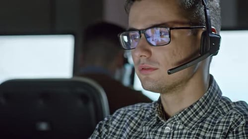 Young Adult Man Talking with Headset in Office