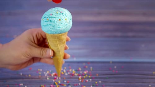 Adding Cherry on Top of Ice Cream Cone
