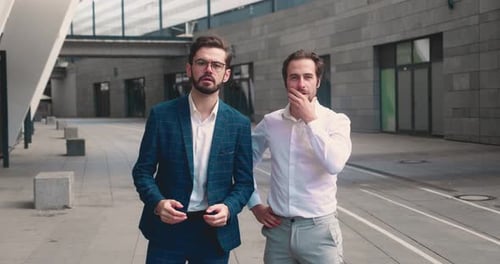 Young Businessmen Celebrate Success Together in Urban Setting