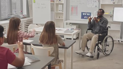 Black Man in Wheelchair Giving Chemistry Lesson for School Children