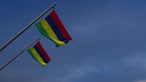 Two Mauritius Flags Waving Against Blue Sky