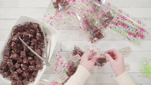 Flat lay. Step by step. Packaging homemade macadamia fudge into small gift bags.