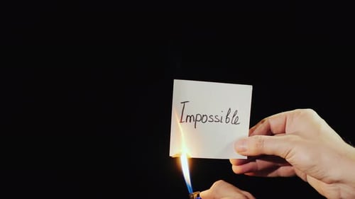 Un homme brûle un papier avec l'inscription Impossible
