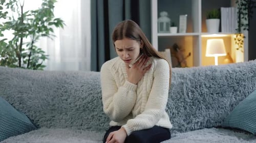 Woman Coughing at Home with Sore Throat