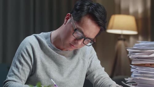 Close Up Of Asian Man Working With Documents At The Home