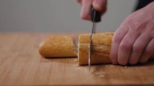 Bäcker zerreißt frisches Brot auf einer Hälfte