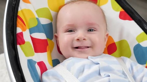 Smiling Infant in Baby Bouncer Close Up