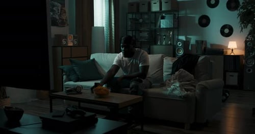 Young Adult Relaxing on Couch Watching Television