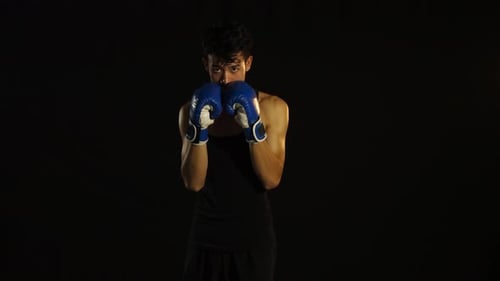 Man Practicing Boxing Punches Wearing Blue Gloves