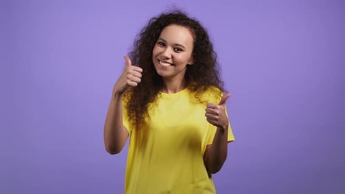 Pretty Woman Showing Thumb Up Like Sign Over Violet Studio Background