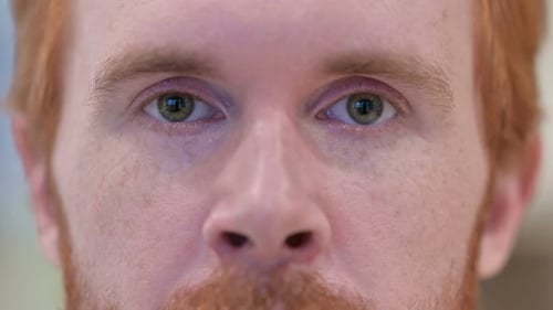 Close Up of Blinking Eyes of Redhead Man Looking at the Camera