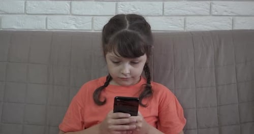 Young Child Uses Smartphone in Home Interior