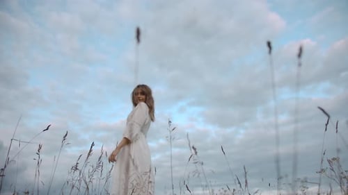 Young Woman Walking in a Rural Grassy Field