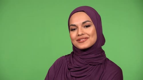 A Young Beautiful Muslim Woman Talks to the Camera with a Smile Closeup Green Screen Background