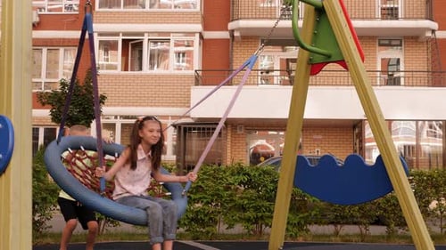 Children Playing on a Web Swing at Playground