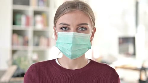 Young Woman Wearing Protective Face Mask Stares