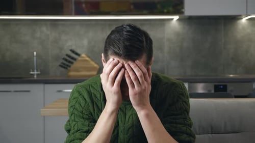 Stressed Man Sitting in Modern Kitchen