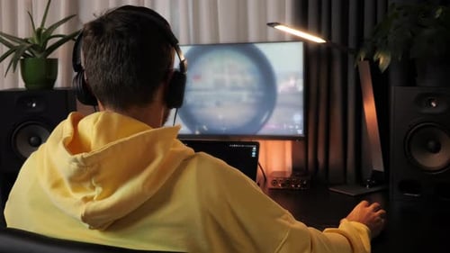 Professional gamer in headphones having live stream playing online video game.