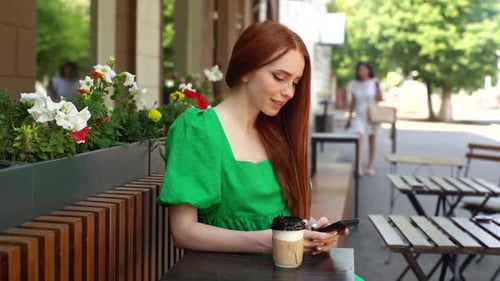 Red Haired Woman Using Mobile Phone in Cafe