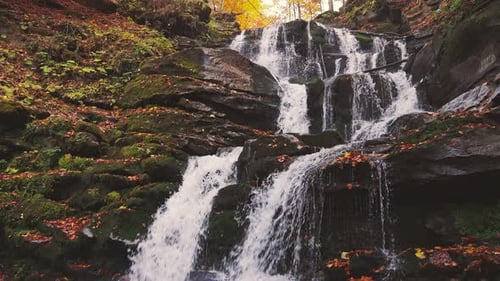 Waterfall Falling Down Mountain Slope in Autumn Forest