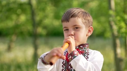 Entzückender Junge spielt auf Holzbläserflöte Ukrainisch Sopilka