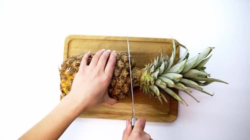 Adult Cutting Pineapple on Wooden Cutting Board