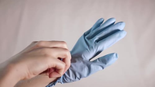 Hand Puts on Blue Surgical Glove and Approves
