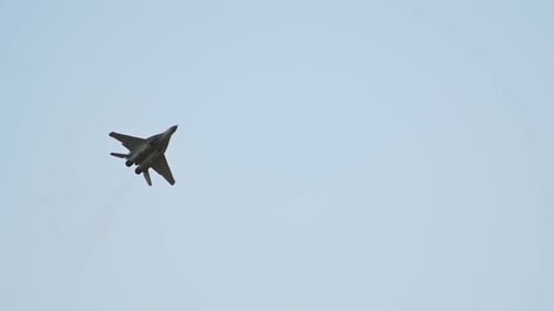 A Green Military Reactive Plane Flying in the Clear Sky and Performing a Show