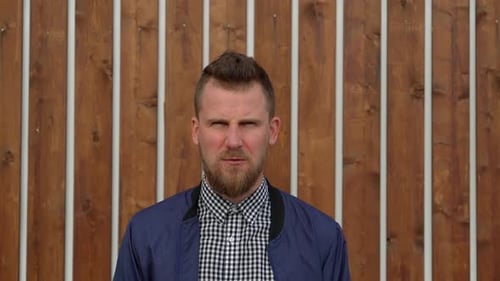 Bearded Man Yelling in Frustration Against Wall