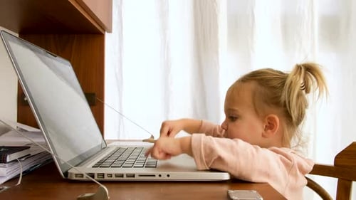 Child Types on Laptop Computer at Desk