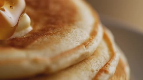 Honig auf einen Stapel Pfannkuchen gießen. Zeitlupe.