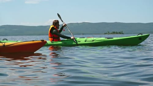 Man Kayaking on a Lake, Summer Day