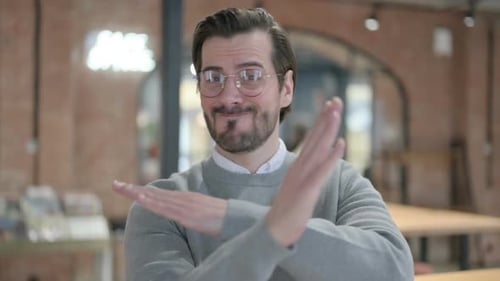 Portrait of Young Man Showing No Sign By Arm Gesture Denial