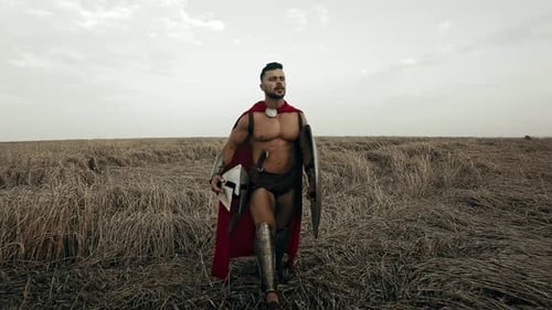 Shirtless Spartan Walking in Dry Field.