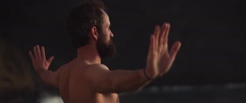 Homem fazendo qigong à beira-mar