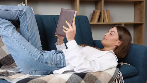 Woman Relaxing on Sofa Reading a Book