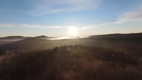 Flight Over the Misty Forest on Morning with Fog and Sun Rays on Treetops at Mountain Sunrise