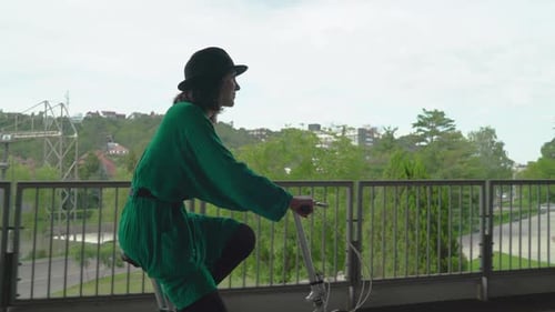 Woman Riding Bicycle on Bridge Path