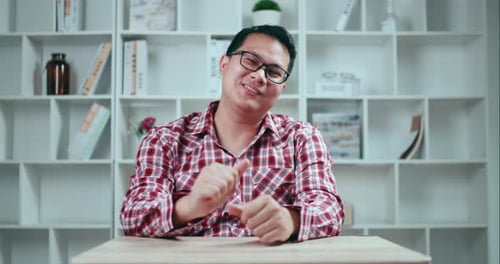 Smiling Man Talking and Gesturing Indoors