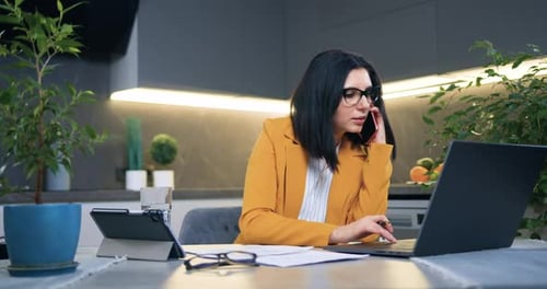 Woman Working at Home with Laptop and Phone