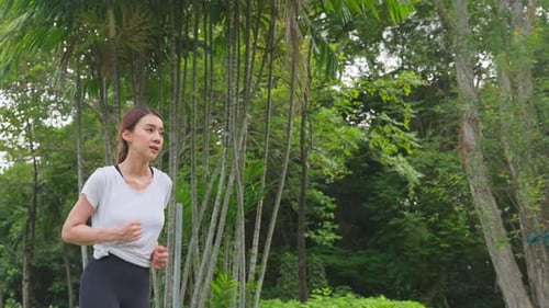 Asian young beautiful sport woman running on street in public park.