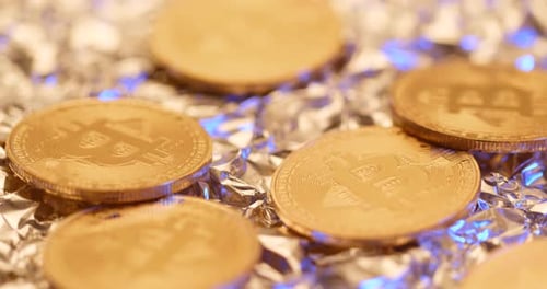 Gold Bitcoin Coins on Silver Foil, Macro Shot