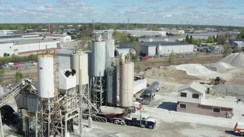 Cement Factory Buildings and Big Reservoirs with Materials Against Industrial Town at Hills Foot on