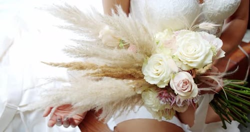 Bride in Lingerie and Holds a Bouquet of Flowers. Bride's Morning. Close Up