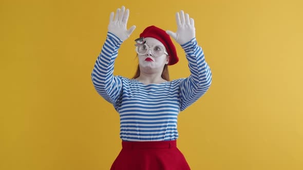 Female mime shows a pantomime wall, on an orange background. European ...
