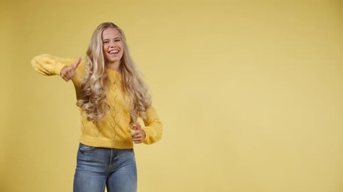 Young Woman Presents, Gives Thumbs Up on Yellow