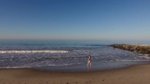 Woman Walking On The Beach
