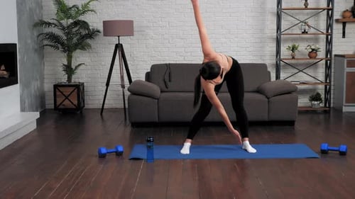 Woman Stretching on Yoga Mat at Home