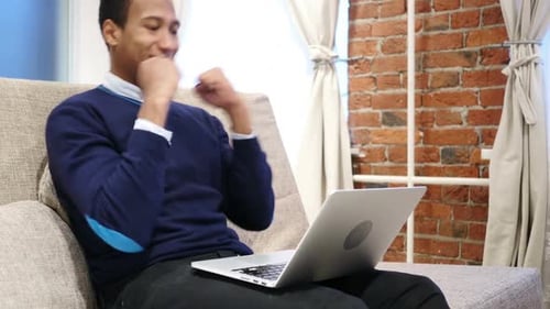 Young Man Working On Laptop at Home