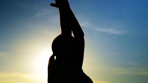 Woman performing yoga on the beach